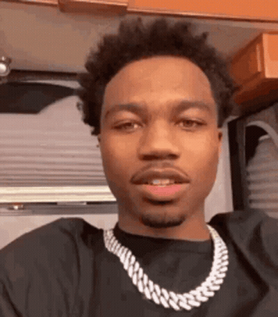 A Close Up Of A Man Wearing A Necklace . GIF