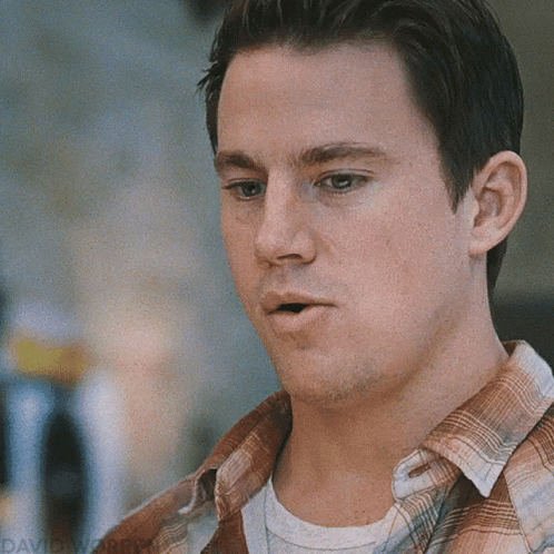A Close Up Of A Man Wearing A Plaid Shirt And A White Shirt GIF