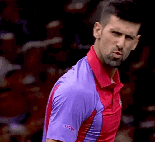 A Close Up Of A Man Wearing A Purple Shirt That Says Lacoste GIF