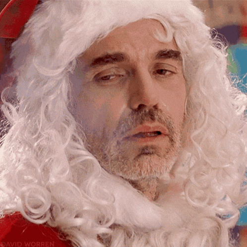 A Close Up Of A Man Wearing A Santa Wig GIF