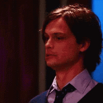 A Close Up Of A Man Wearing A Tie And Sweater . GIF