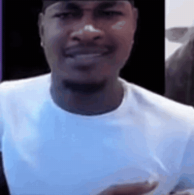 A Close Up Of A Man Wearing A White Shirt And A Black Hat . GIF