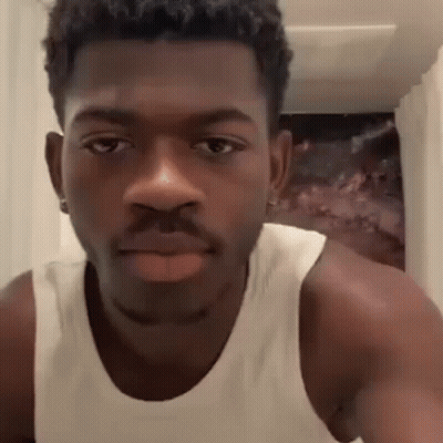 A Close Up Of A Man Wearing A White Tank Top Making A Face . GIF