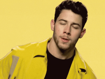 A Close Up Of A Man Wearing A Yellow Jacket And A Black Shirt With His Eyes Closed . GIF