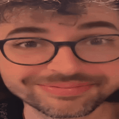 A Close Up Of A Man Wearing Glasses And A Beard With His Eyes Closed GIF