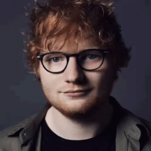 A Close Up Of A Man Wearing Glasses And A Black Shirt GIF