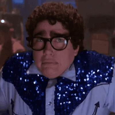 A Close Up Of A Man Wearing Glasses And A Blue Sequined Jacket . GIF