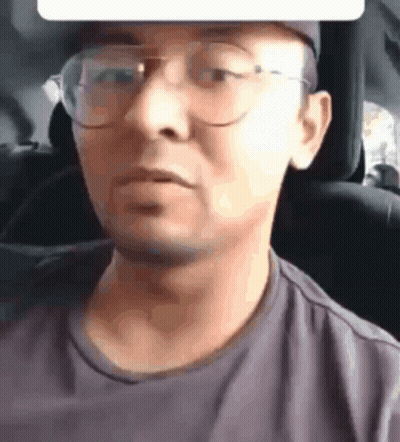 A Close Up Of A Man Wearing Glasses And A Hat GIF