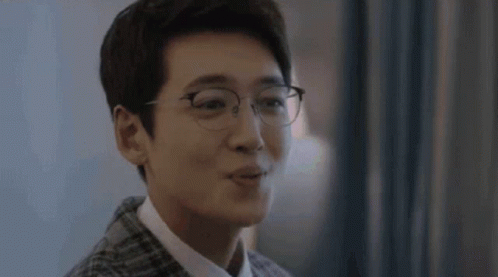 A Close Up Of A Man Wearing Glasses And A Plaid Jacket . GIF