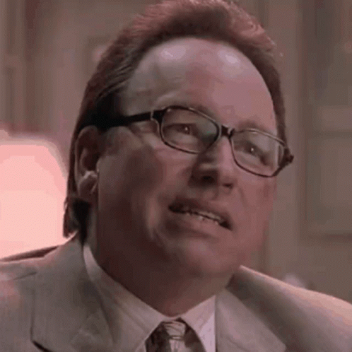 A Close Up Of A Man Wearing Glasses And A Suit . GIF