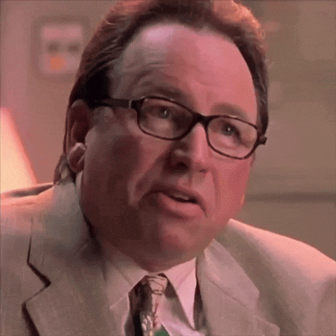 A Close Up Of A Man Wearing Glasses And A Suit And Tie GIF