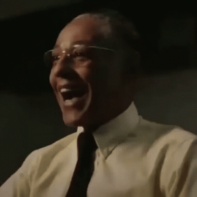 A Close Up Of A Man Wearing Glasses And A Yellow Shirt Laughing . GIF