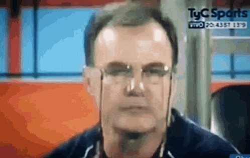 A Close Up Of A Man Wearing Glasses And Headphones On A Television Screen . GIF