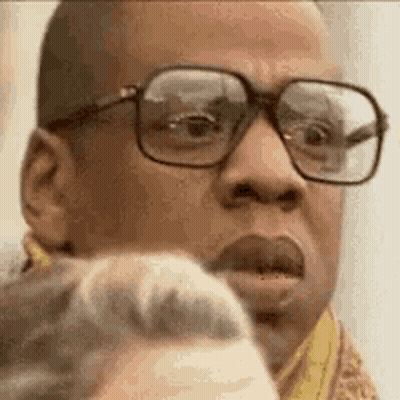 A Close Up Of A Man Wearing Glasses Making A Face . GIF