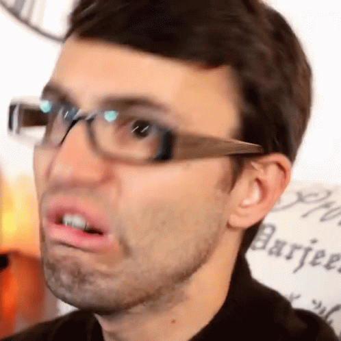 A Close Up Of A Man Wearing Glasses Making A Face . GIF