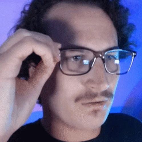 A Close Up Of A Man Wearing Glasses With A Mustache GIF