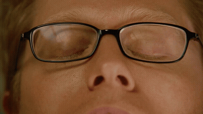 A Close Up Of A Man Wearing Glasses With His Eyes Looking Up GIF