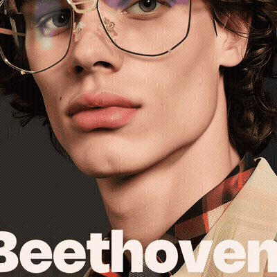 A Close Up Of A Man Wearing Glasses With The Word Beethoven In White GIF