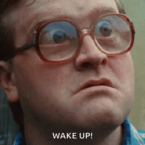 A Close Up Of A Man Wearing Glasses With The Words Wake Up Written Below Him GIF