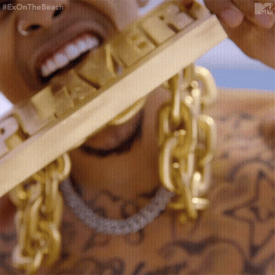 A Close Up Of A Man Wearing Gold Chains And A Gold Bar That Says Exon The Beach GIF
