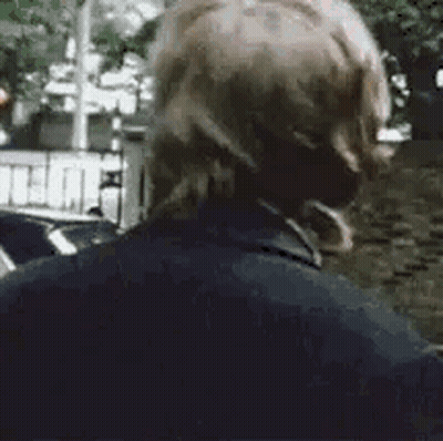 A Close Up Of A Man Wearing Headphones Standing On A Street . GIF