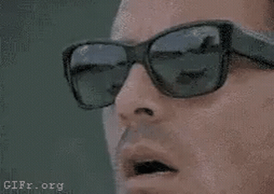 A Close Up Of A Man Wearing Sunglasses And A Cell Phone . GIF