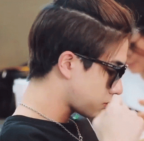 A Close Up Of A Man Wearing Sunglasses And A Chain Around His Neck . GIF