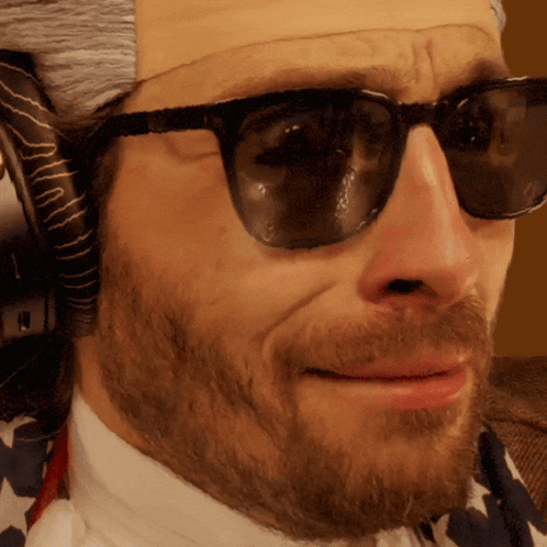A Close Up Of A Man Wearing Sunglasses And A Fake Head GIF