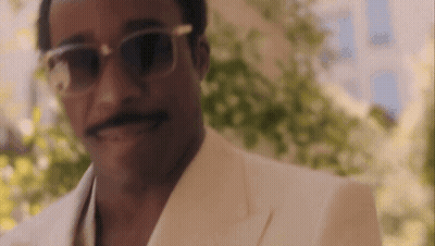 A Close Up Of A Man Wearing Sunglasses And A White Suit . GIF