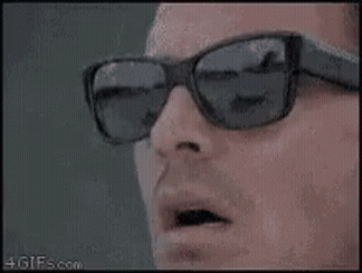A Close Up Of A Man Wearing Sunglasses And Looking At Something . GIF