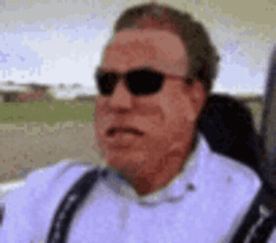 A Close Up Of A Man Wearing Sunglasses And Suspenders . GIF