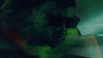 A Close Up Of A Man Wearing Sunglasses In The Dark GIF