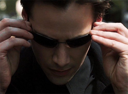A Close Up Of A Man Wearing Sunglasses Looking Down GIF