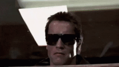 A Close Up Of A Man Wearing Sunglasses Looking Out A Window GIF