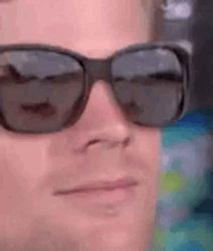 A Close Up Of A Man Wearing Sunglasses On His Face . GIF