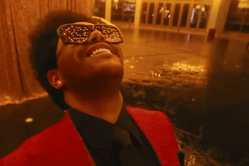 A Close Up Of A Man Wearing Sunglasses With Gold Dots On The Lenses GIF