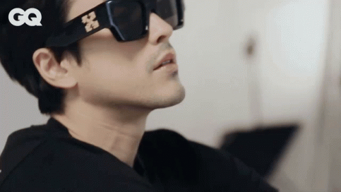 A Close Up Of A Man Wearing Sunglasses With The Gq Logo In The Corner GIF