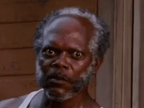 A Close Up Of A Man With A Beard And A White Tank Top Making A Funny Face . GIF