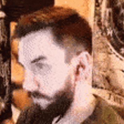 A Close Up Of A Man With A Beard Covering His Ear . GIF