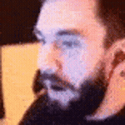 A Close Up Of A Man With A Beard Talking On A Phone . GIF