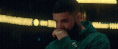 A Close Up Of A Man With A Beard Wearing A Green Hoodie . GIF