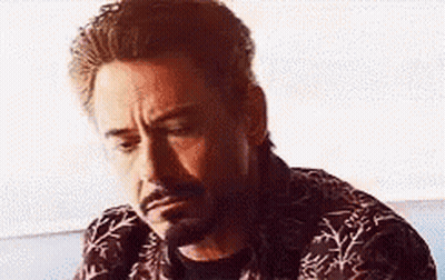 A Close Up Of A Man With A Beard Wearing A Shirt And Looking Down . GIF