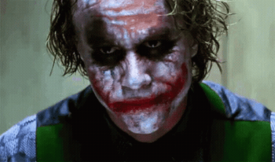 A Close Up Of A Man With A Joker Makeup On His Face Looking At The Camera . GIF
