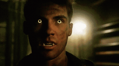 A Close Up Of A Man With Glowing Yellow Eyes And Teeth . GIF