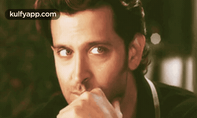 A Close Up Of A Man With His Hand On His Chin . GIF