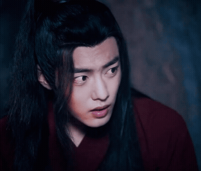 A Close Up Of A Man With Long Black Hair Wearing A Red Shirt . GIF
