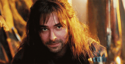 A Close Up Of A Man With Long Hair And A Beard Smiling . GIF