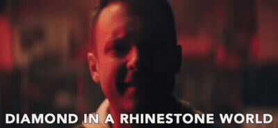 A Close Up Of A Man With The Words Diamond In A Rhinestone World Above Him GIF