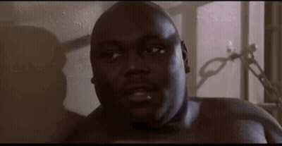 A Close Up Of A Man Without A Shirt Looking At The Camera In A Room . GIF