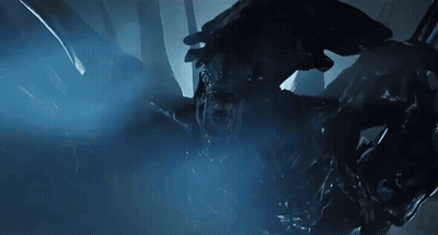 A Close Up Of A Monster In A Dark Room With A Blue Light Behind It GIF